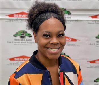 A SERVPRO employee in front of SERVPRO backdrop