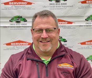 A SERVPRO employee in front of SERVPRO backdrop