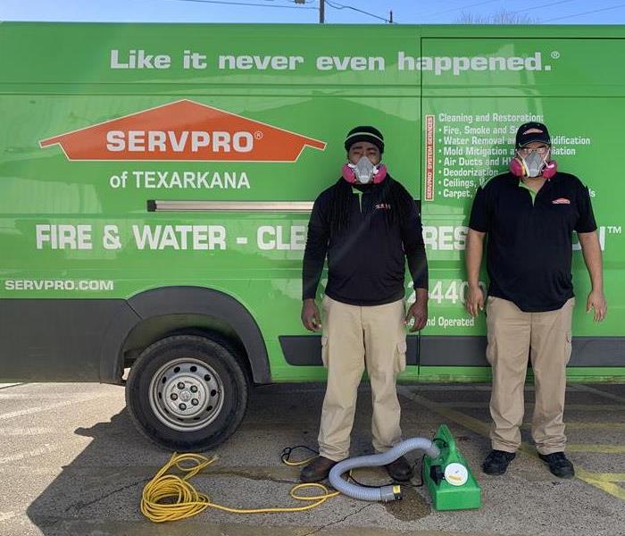SERVPRO employees standing infront of a van with respirators 